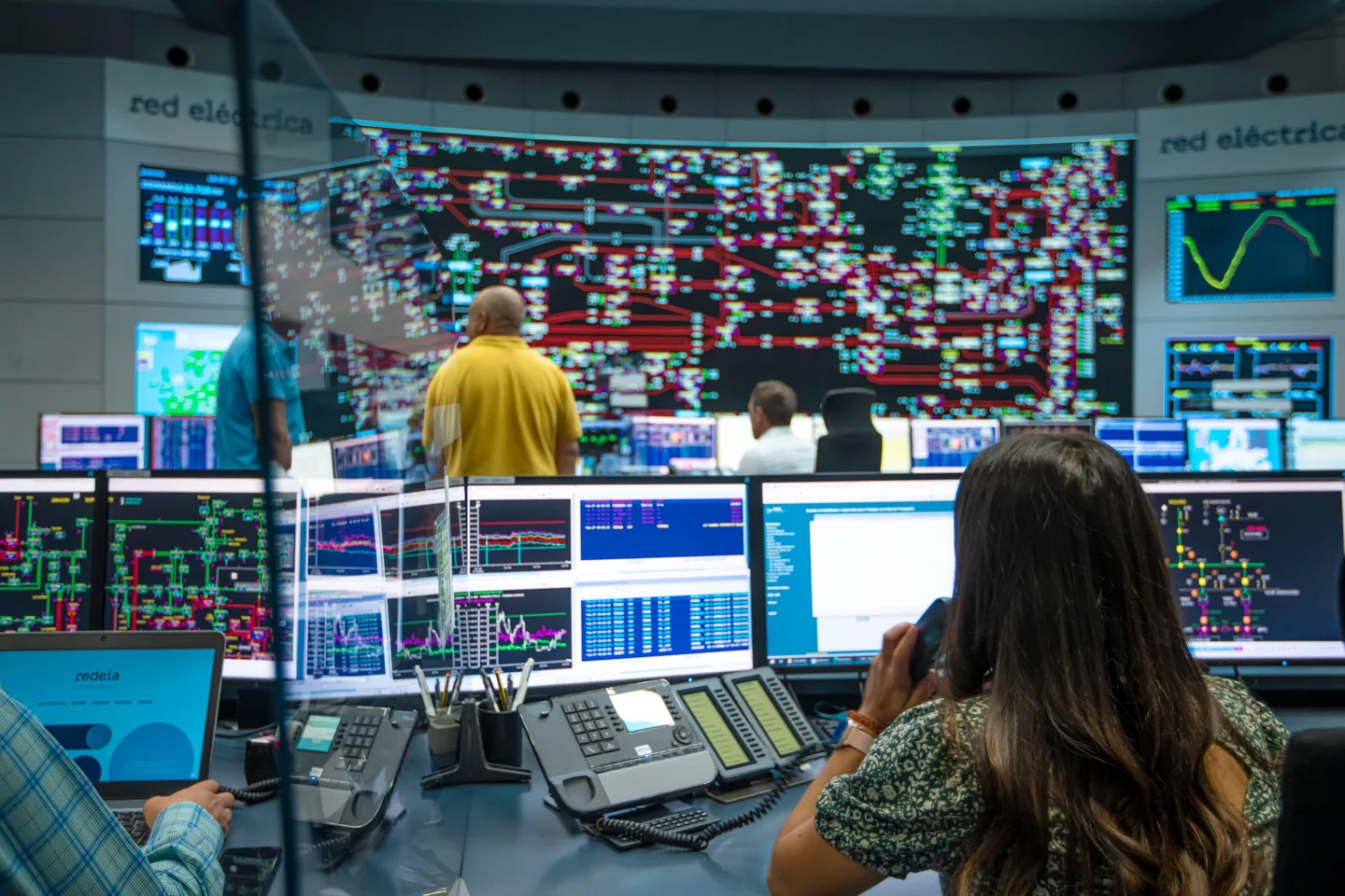 Electricity network operators monitoring the grid in a control room